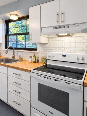 The kitchen end to end: range, dishwasher, microwave, toaster and knife block.